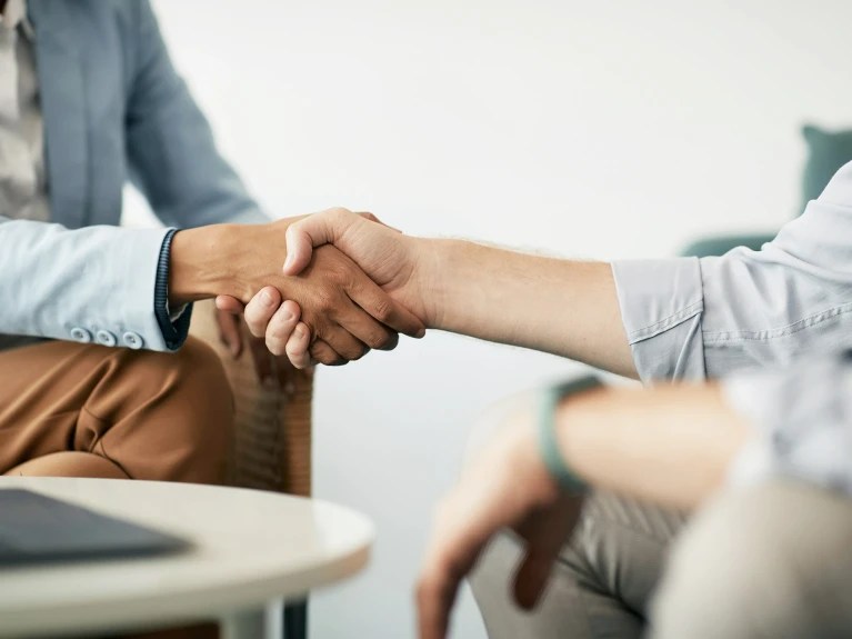 Two people shaking hands in an office