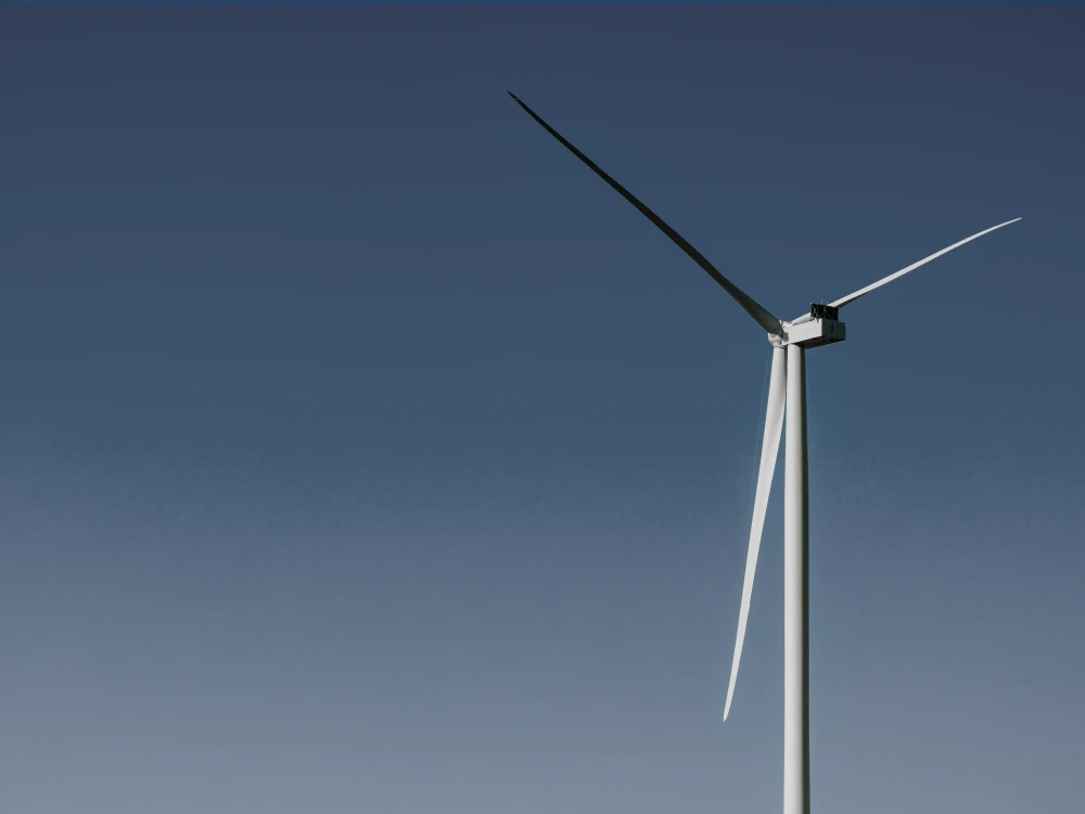 Single wind turbine against a clear blue sky