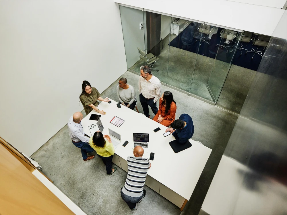 Group of seven people in a modern office having a meeting