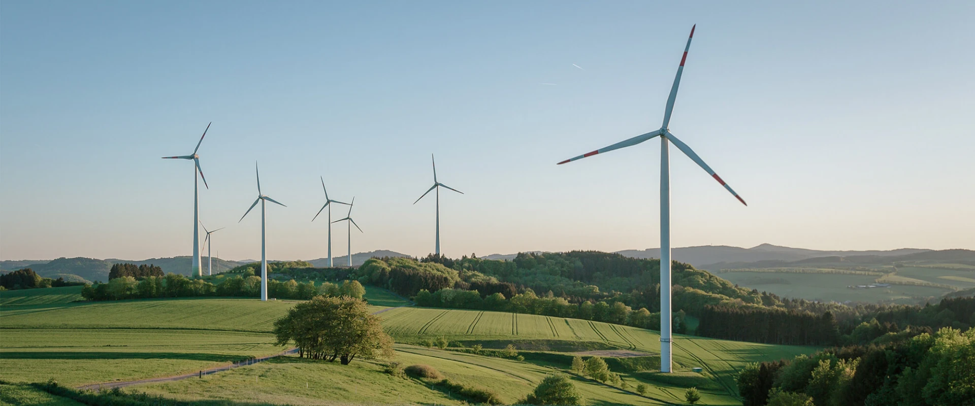 Wind turbines in a hilly landscape at sunrise