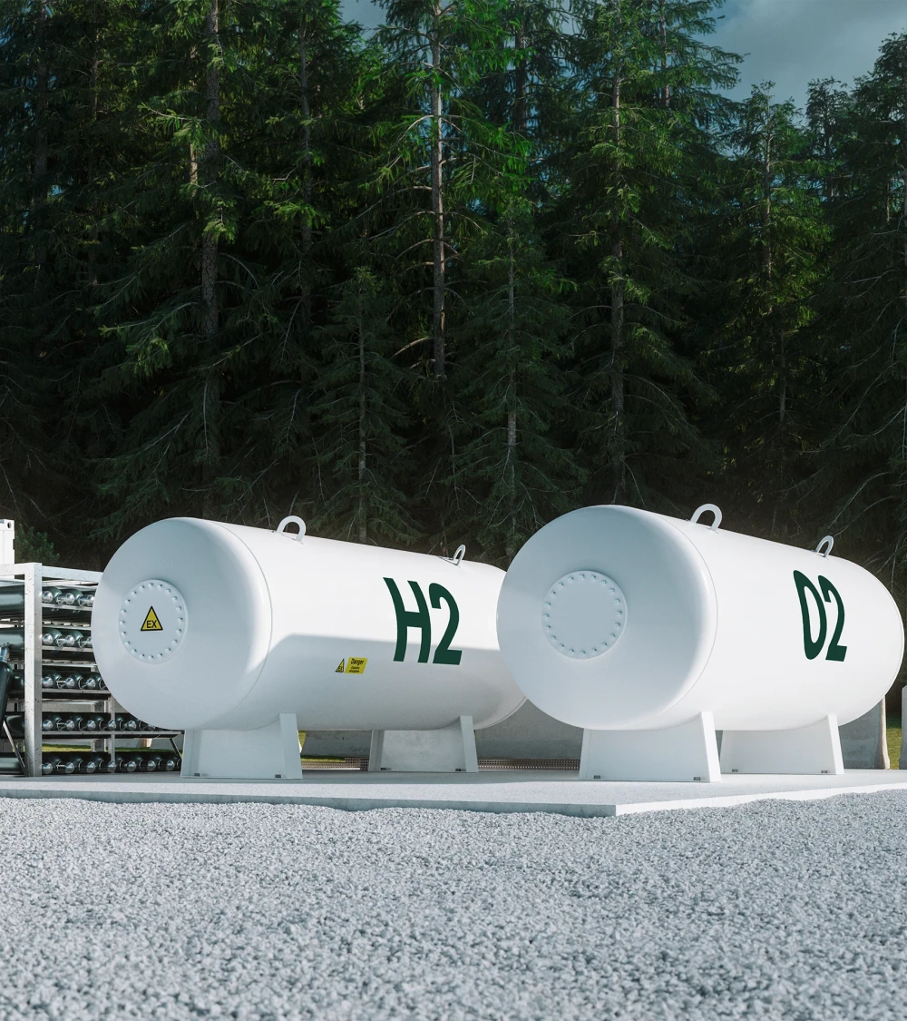 Two large white hydrogen tanks labeled H2 and D2 in front of a forest