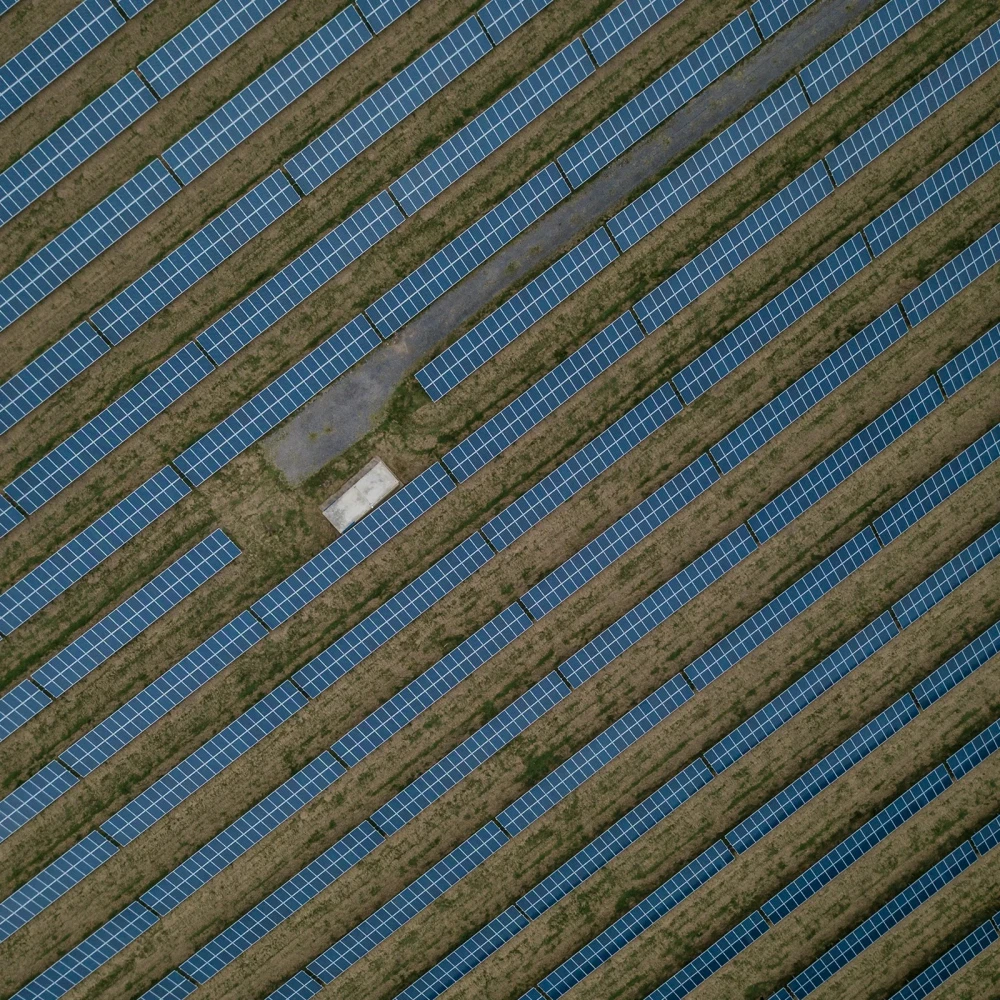 Aerial view of a solar farm with parallel rows of solar panels